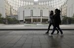 Pedestrians walk past the People's Bank of China headquarters in Beijing.