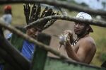 A native Brazilian breaks through the gate of a ranch that was built on property declared an Indian reserve by the federal government.