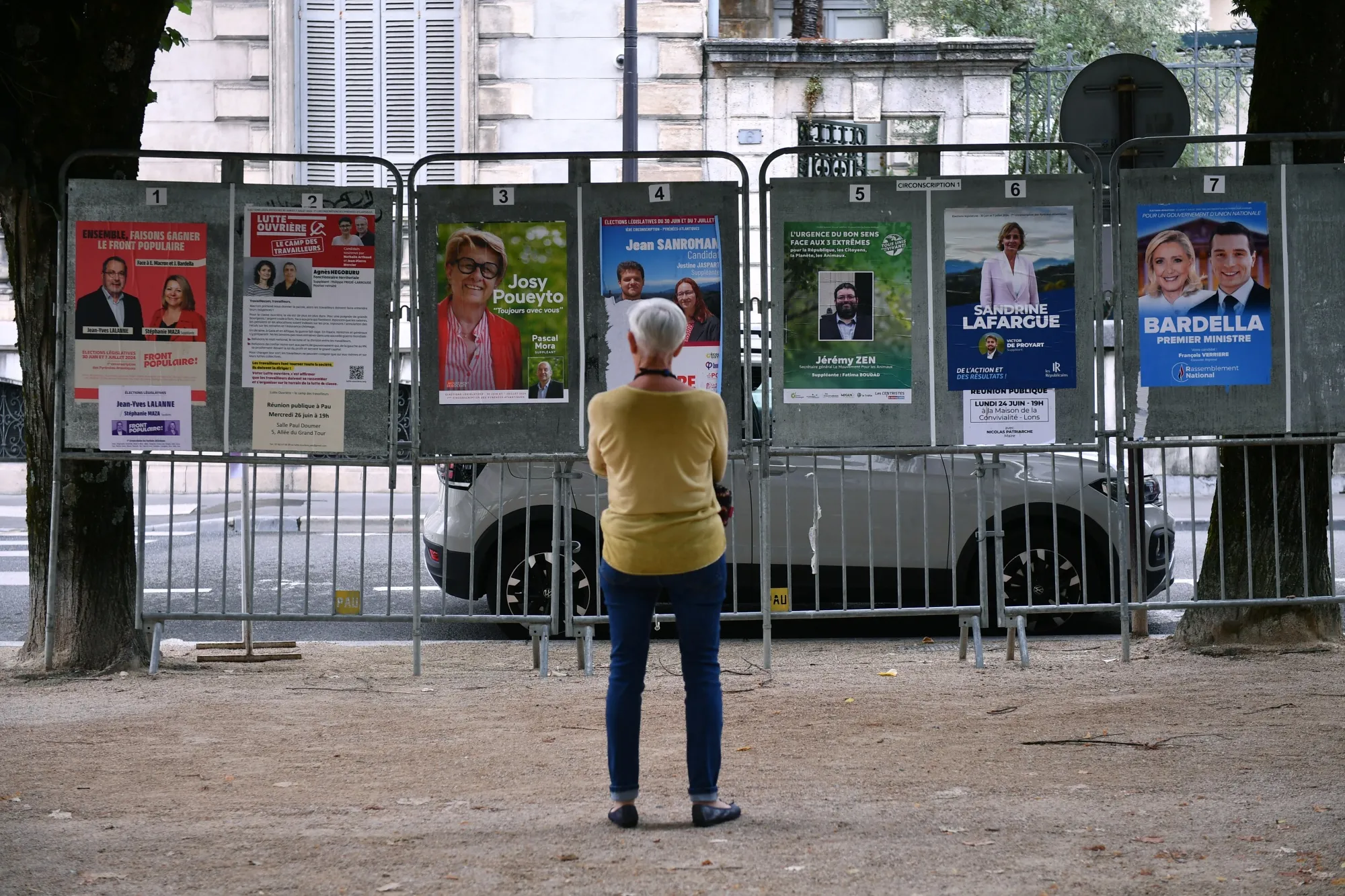 A woman looks at election posters next to a polling station in Pau, France on June 30.