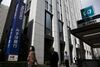 Pedestrians walk past a Mizuho Bank Ltd. branch in Tokyo, Japan.