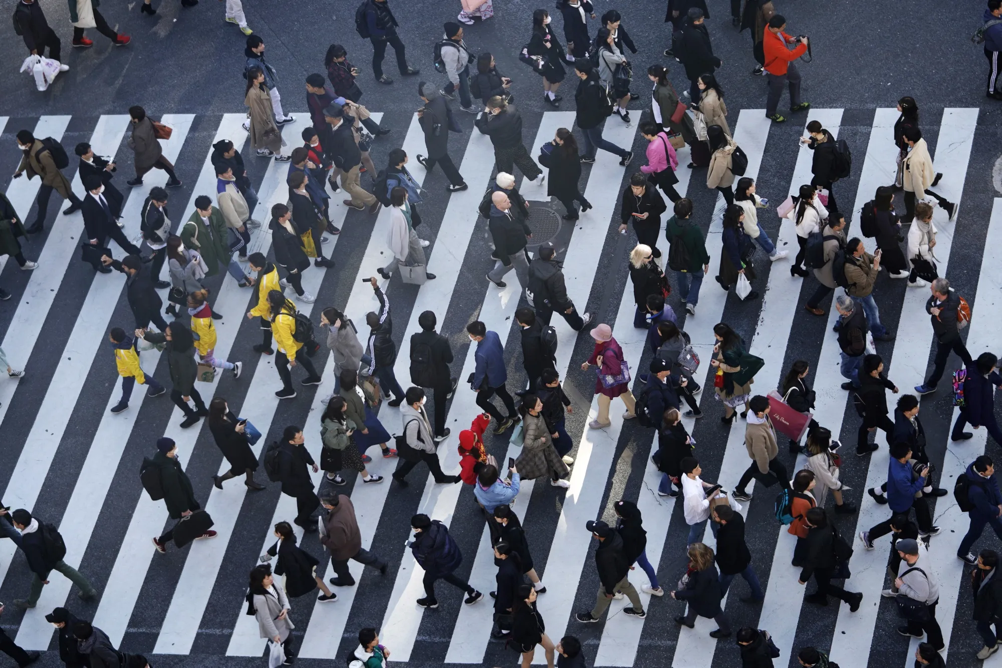Pedestrians cross an intersection in the Shibuya district of Tokyo.