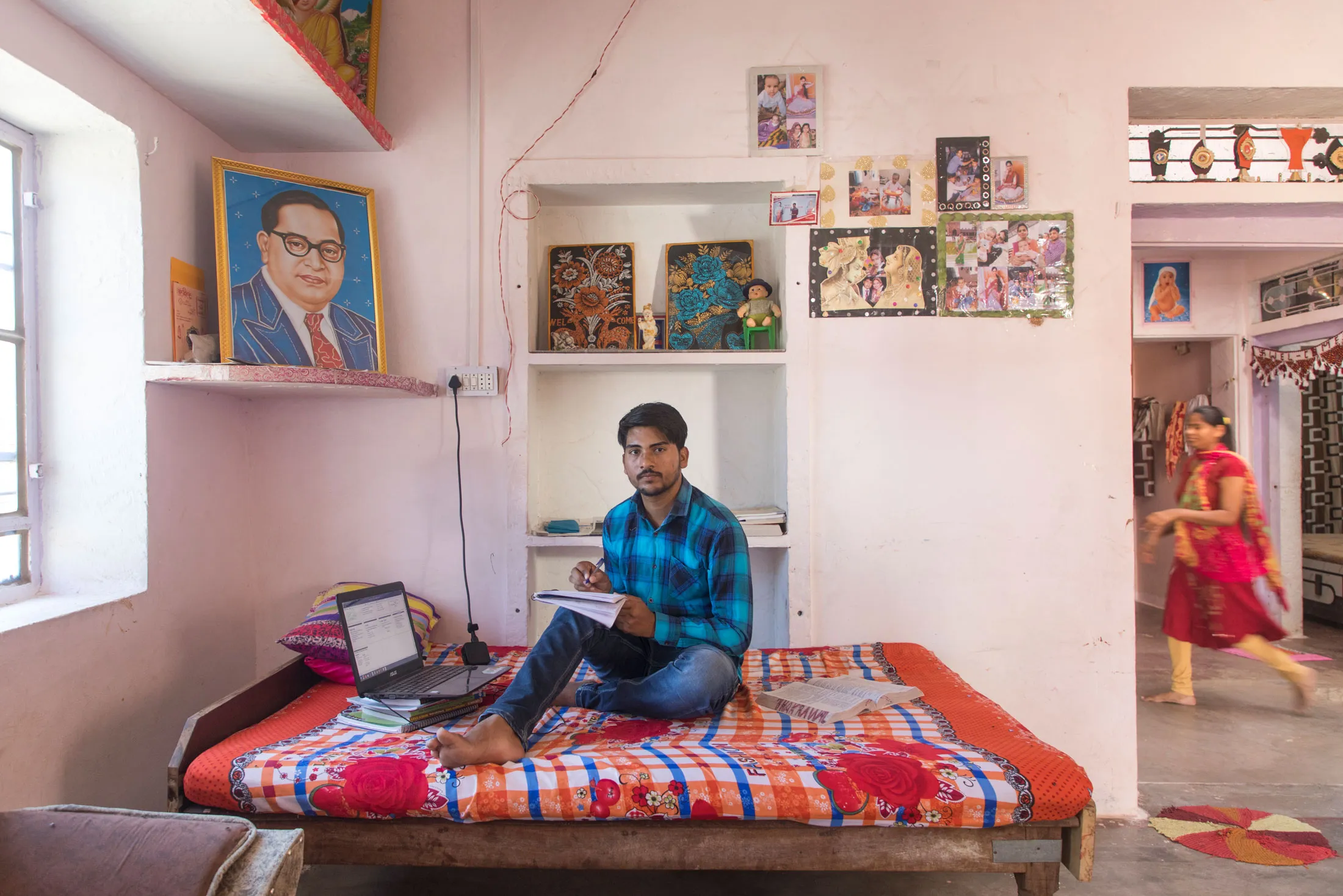 Amit Jatav at home as he tried to continue his studies with his university,&nbsp;IIT Delhi, going online. Behind him is a portrait of B.R. Ambedkar, a Dalit thinker and activist who led the drafting of the Constitution of India and is responsible for the fight against caste discrimination in the country.&nbsp;