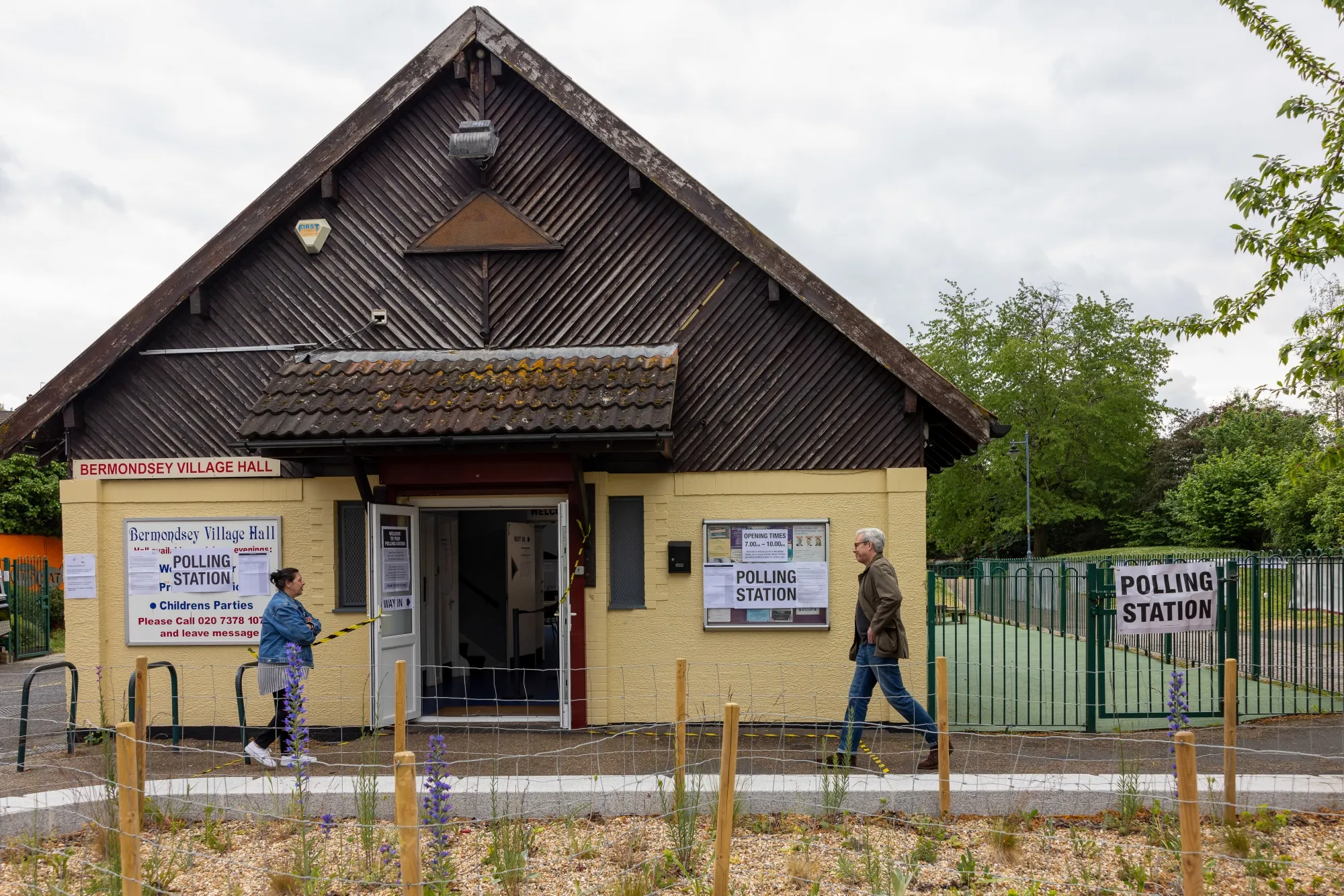 Voters arrive at a polling station setup at Bermondsey Village Hall, in the borough of Southwark, London on May 7.