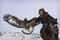 A Kazakh golden eagle hunter flies his eagle on horseback. Shot during the middle of winter, with snow on the ground, these Kazakh golden eagle hunters live and hunt in the Altai Mountains (Altay) around Altantsogts Sum, Bayan-??lgii Province, Western Mongolia