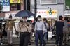 Pedestrians wearing protective face masks cross a road in the Roppongi district of Tokyo, Japan, on Thursday, July 30, 2020. Officials in Japan are planning stricter measures on businesses and group activities as coronavirus cases continue to spread from a concentration around the capital to other urban areas across the country.