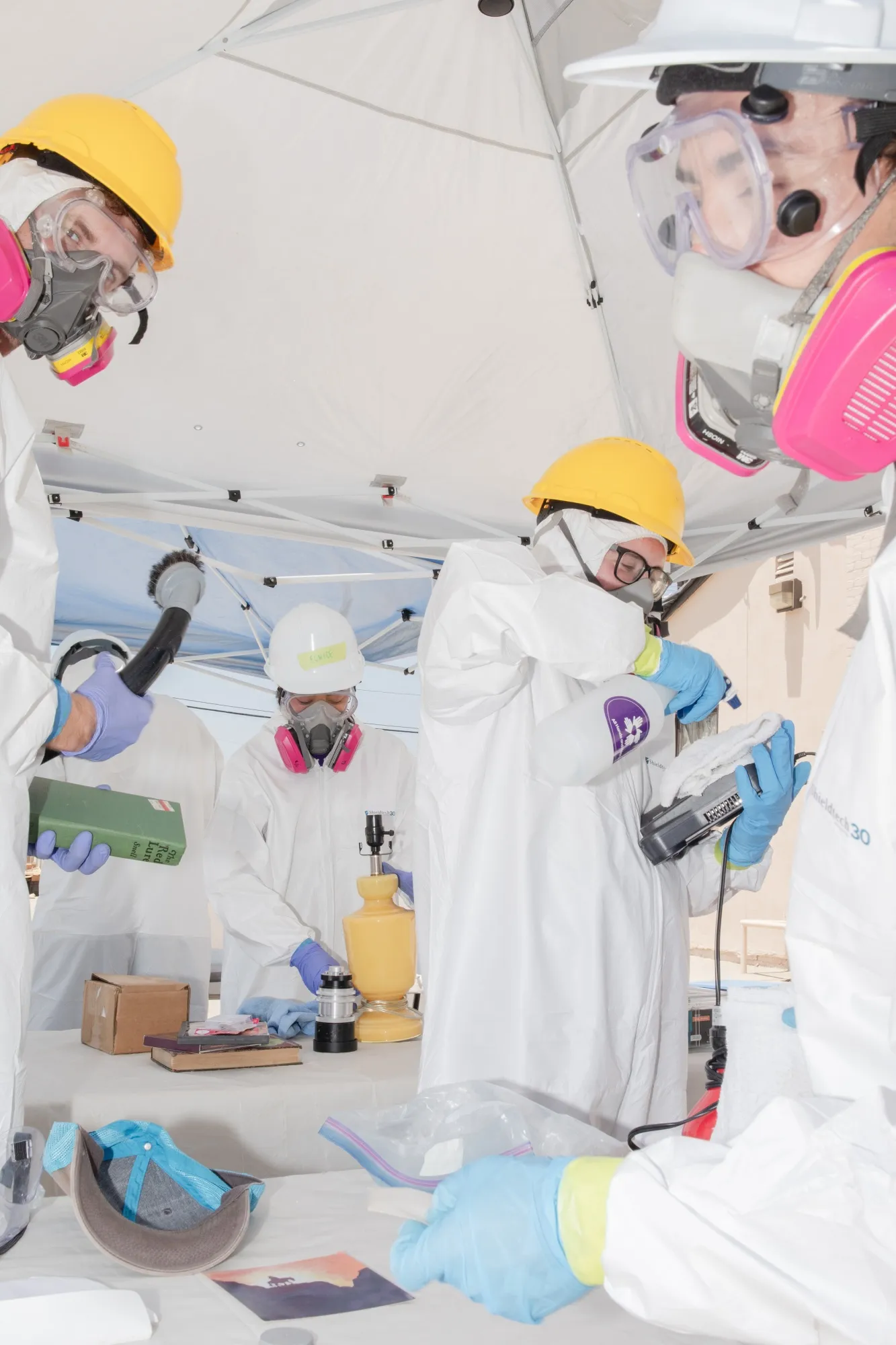 Volunteers with the nonprofit organization All Hands and Hearts vacuum and wipe down items from Elle Schneider’s home.