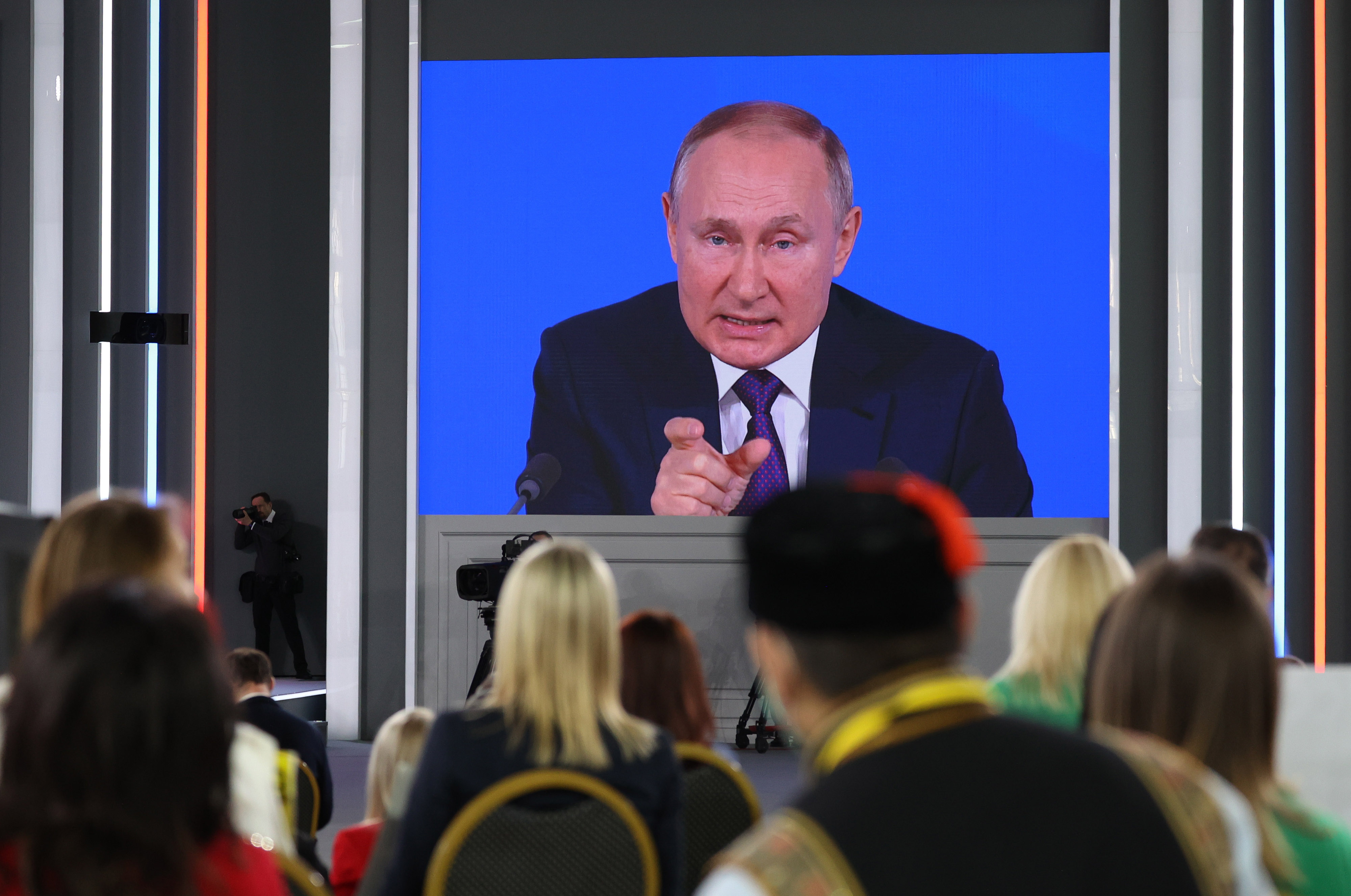 Attendees watch Vladimir Putin during his annual news conference in Moscow on Dec. 23, 2021.&nbsp;