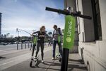 People use a smartphone to unlock&nbsp;Lime shared electric scooters&nbsp;on the Embarcadero in San Francisco.