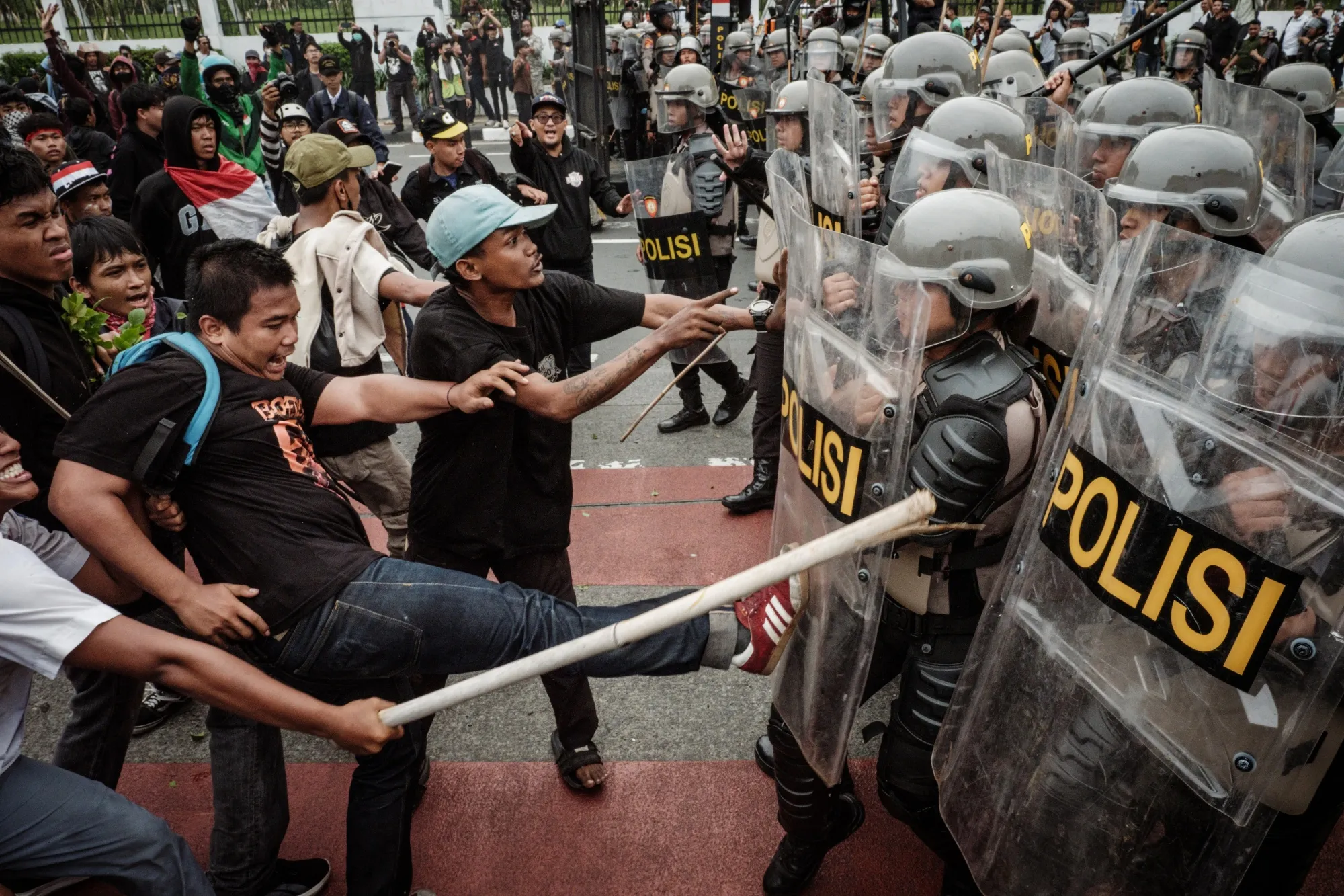 Protesters try to block police advancing with shields during a demonstration in front of the House of Representatives parliament building in Jakarta on Aug. 25.