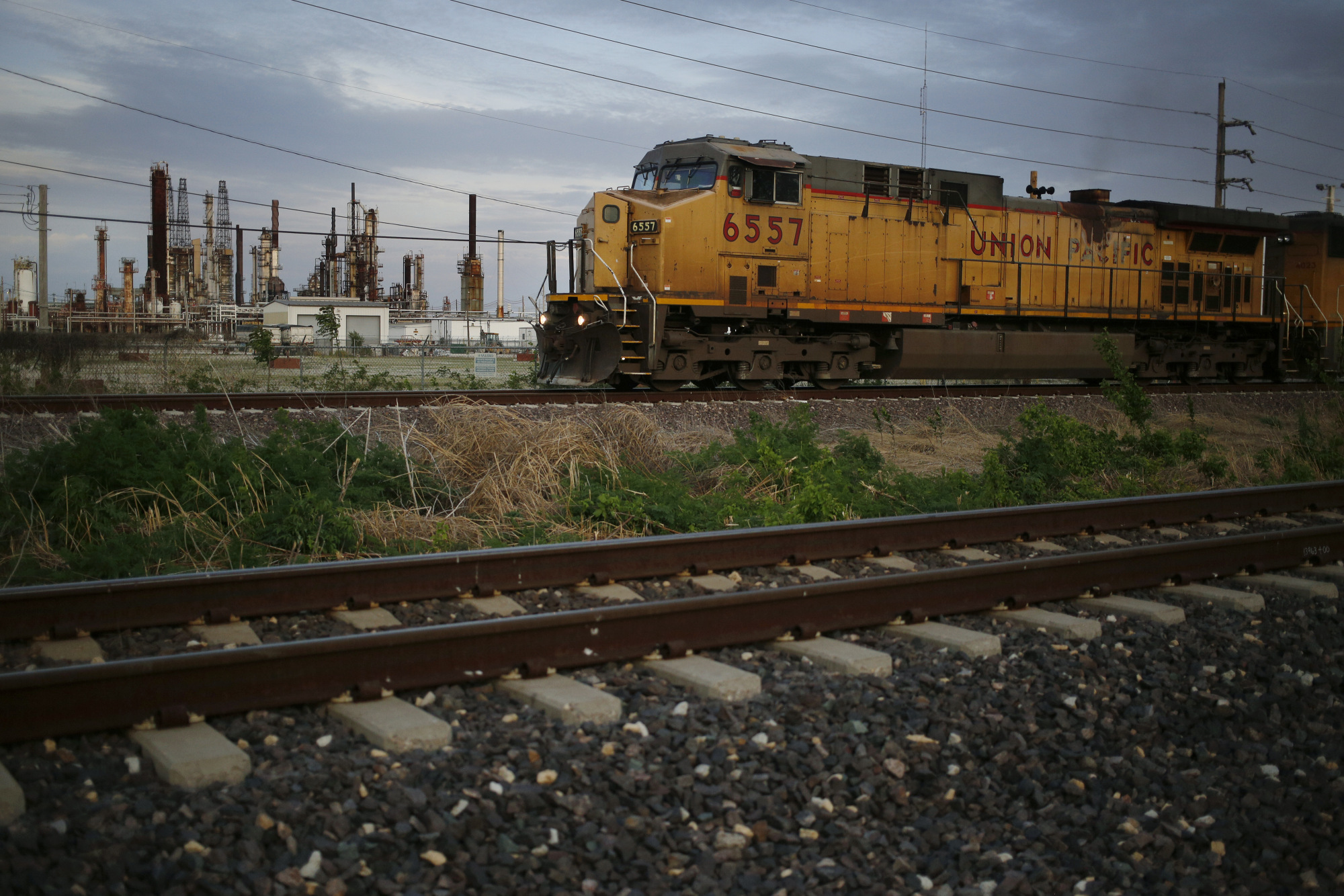 A Union Pacific Corp. freight train passes by an oil refinery in Roxana, Illinois.