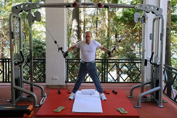 Flexing his muscles.
