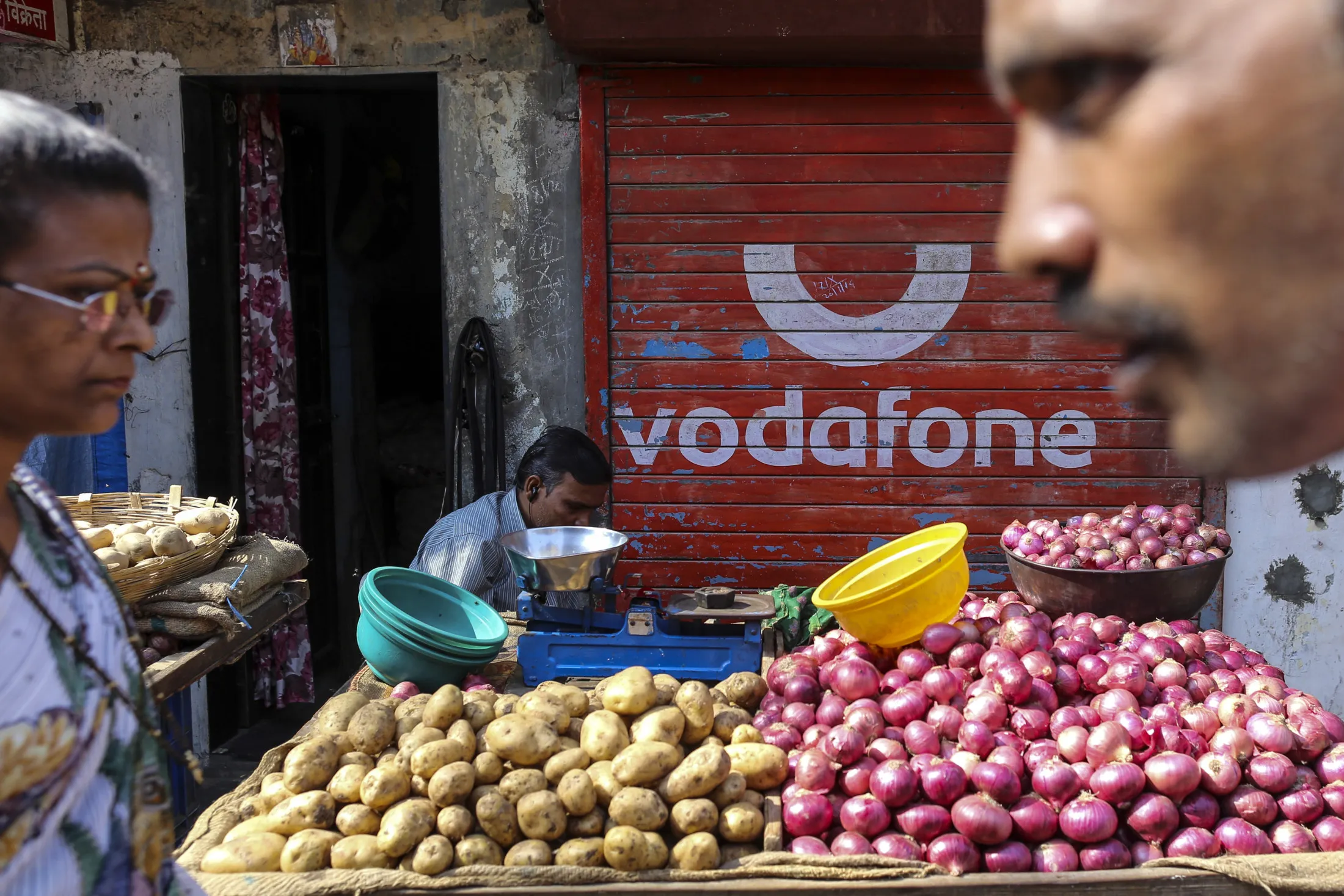 Pedestrians in front of a closed store in Mumbai, India.