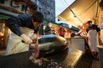 A vender cuts a tuna at a stall after the first auction of the year at Tsukiji Market in Tokyo, Japan.