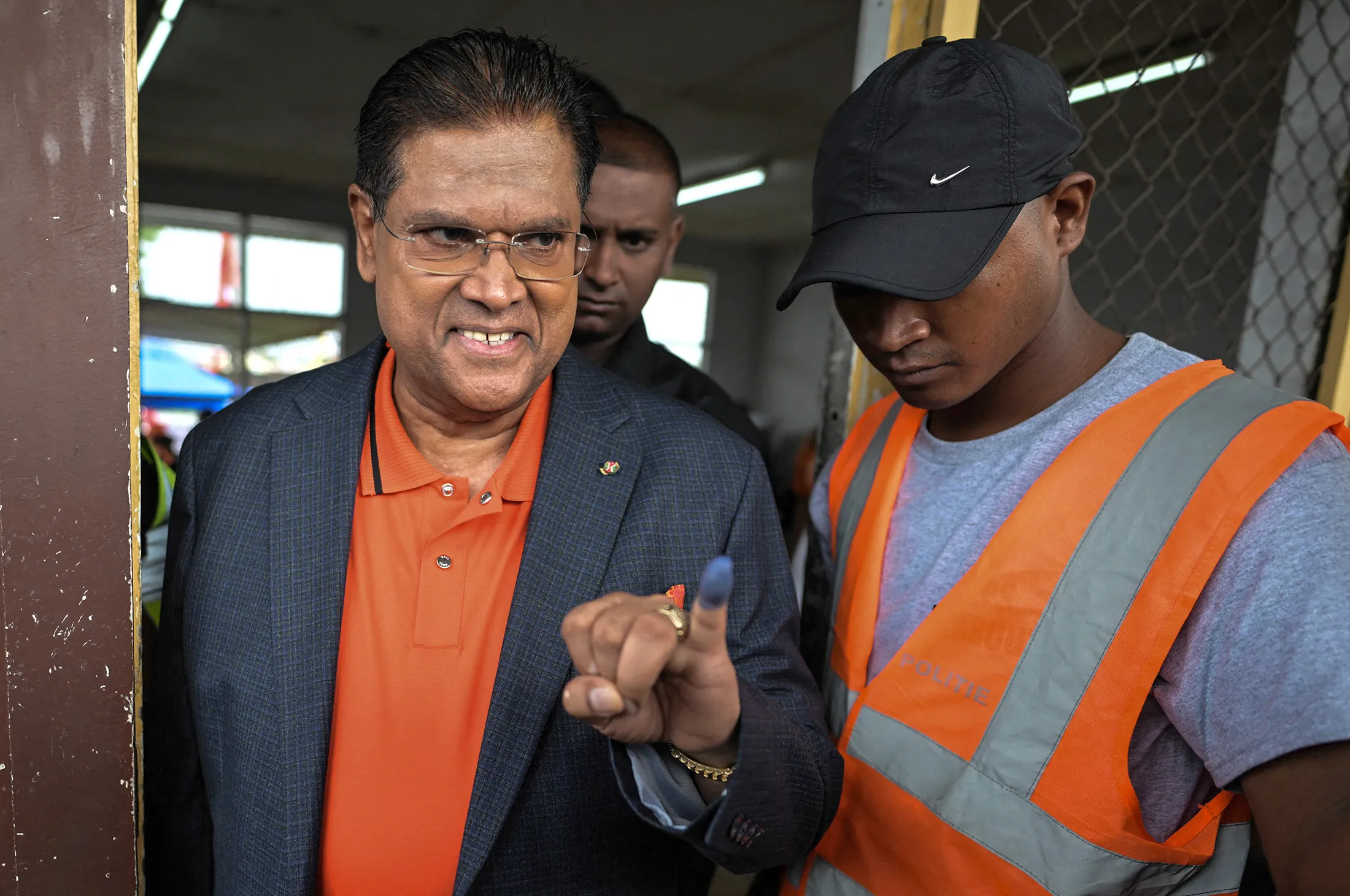 Chandrikapersad Santokhi displays an inked finger after voting at a polling station in Paramaribo, Suriname, on May 25.