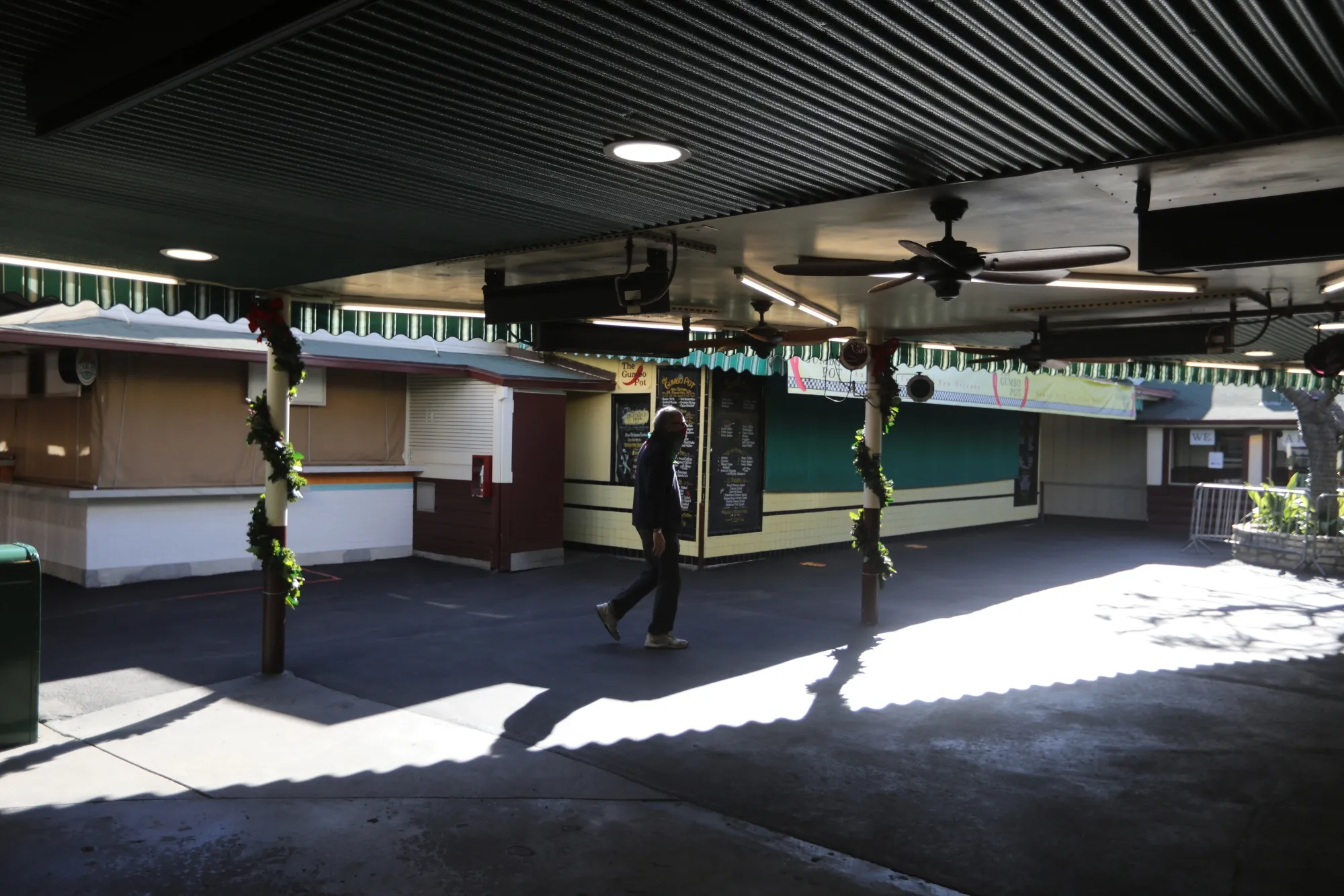 A shopper&nbsp;walks through a farmers market, where seating has been removed, in Los Angeles.