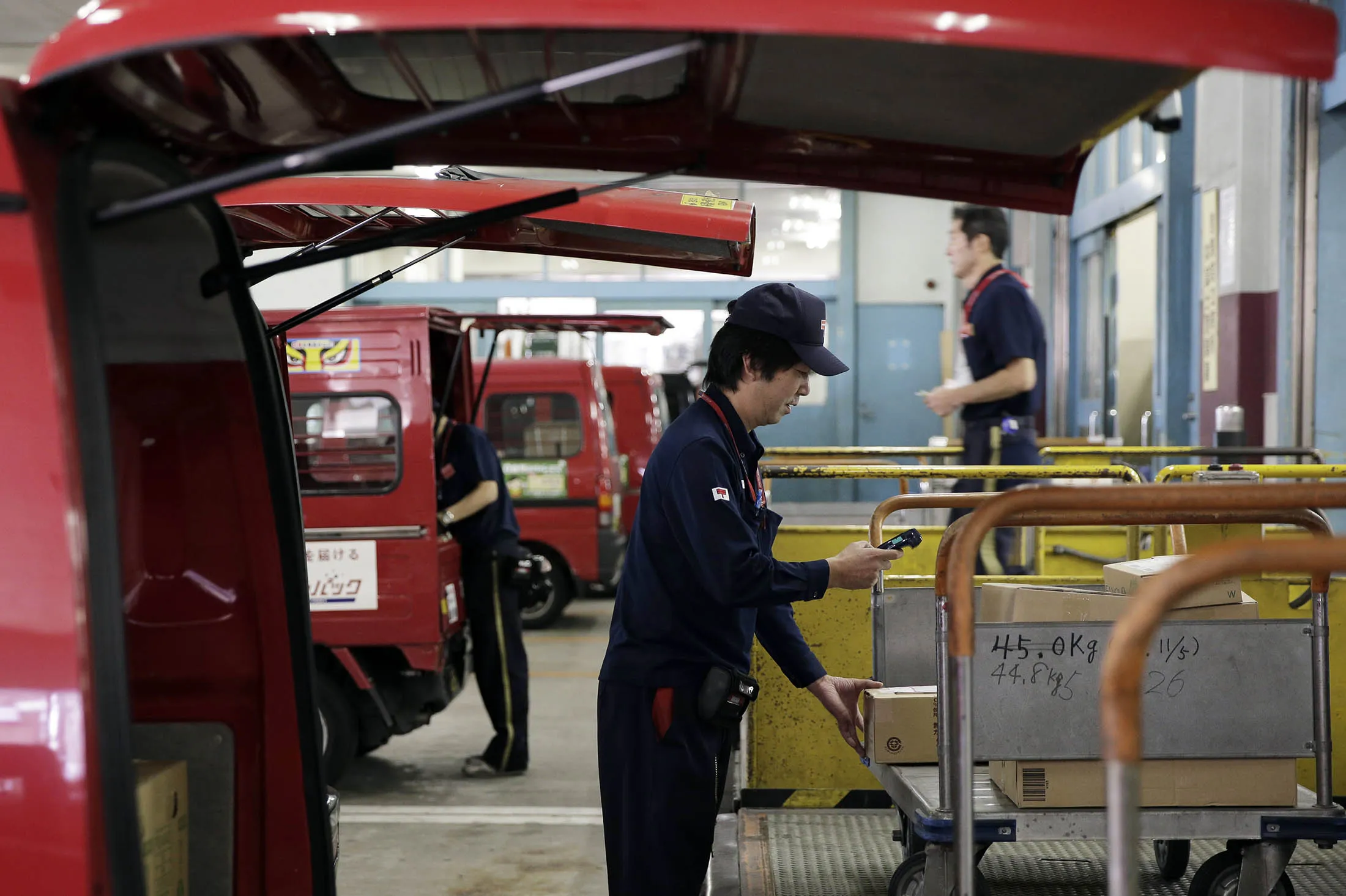 An employee scans a parcel before loading the package onto a van at a Japan Post post office in Tokyo.
