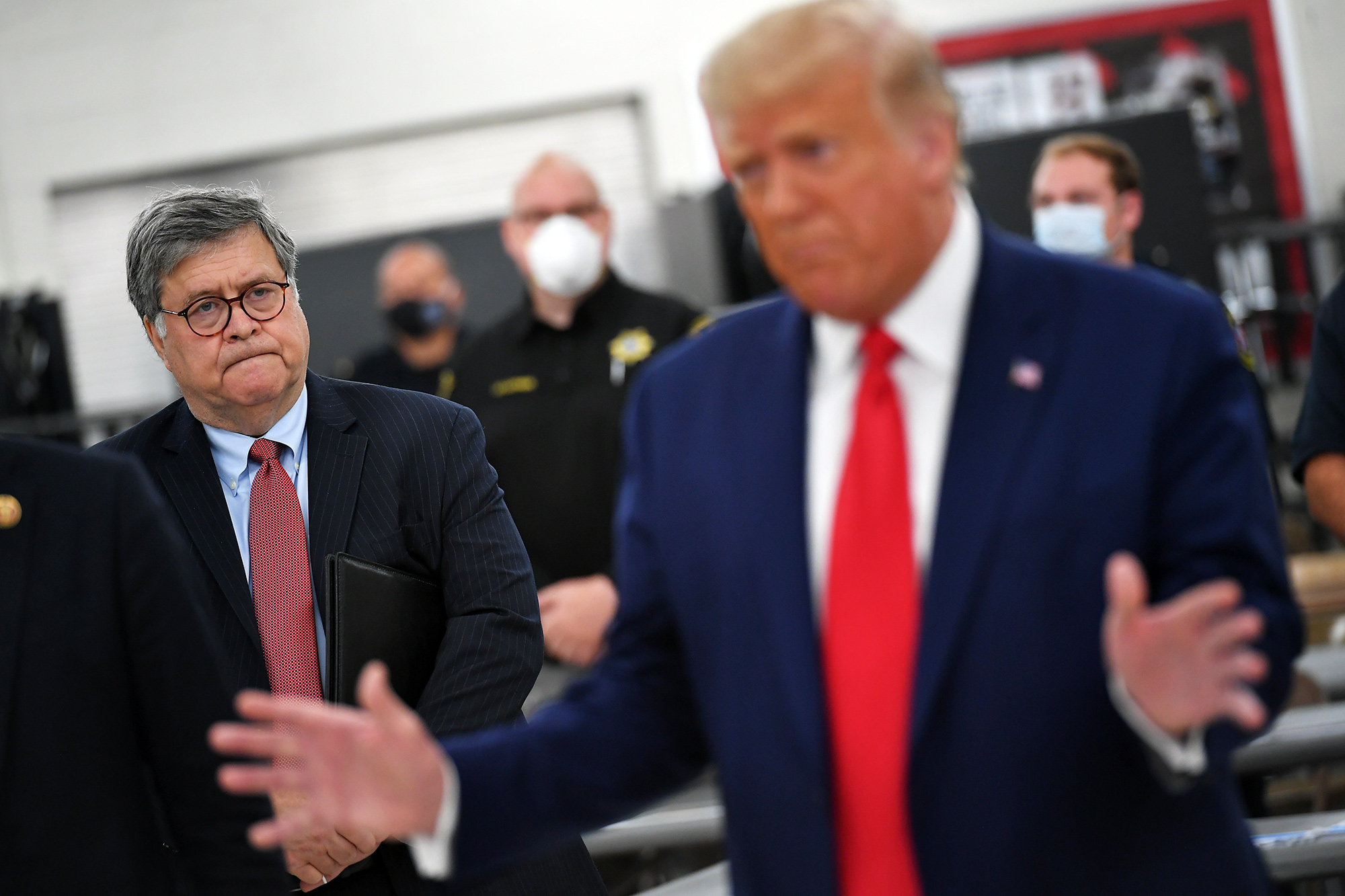 William Barr, left, listens as Donald Trump speaks during a visit to Mary D. Bradford High School in Kenosha, Wisconsin, on Sept. 1.
