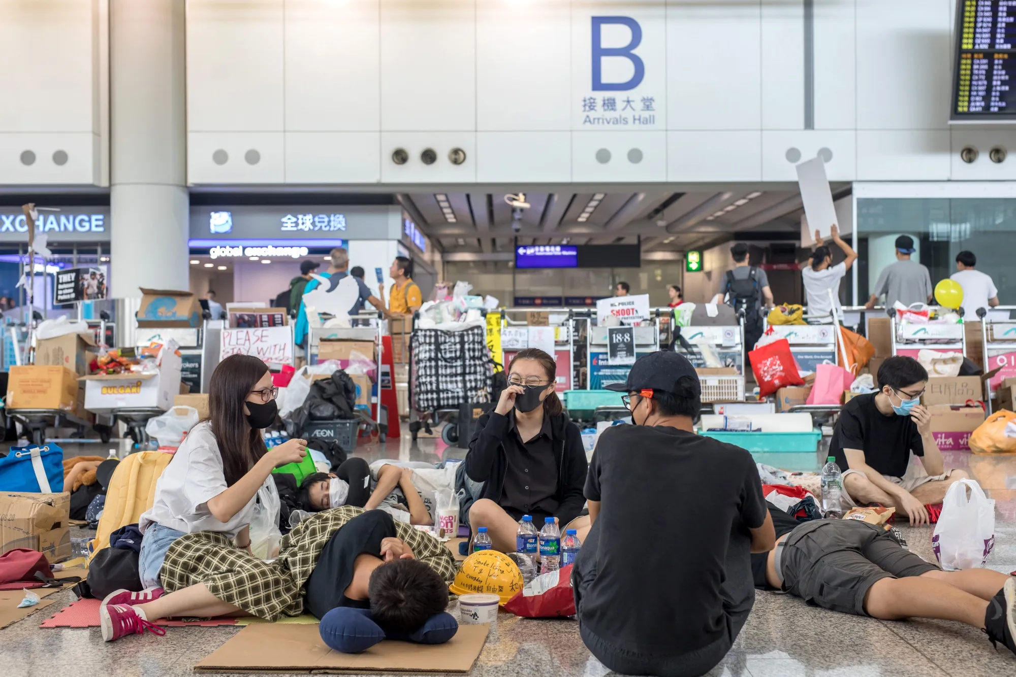 Demonstrators sit in the arrival hall&nbsp;at&nbsp; Hong Kong International Airport on Aug. 14.