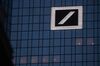 A logo sits illuminated on Deutsche Bank AG headquarters office building in Frankfurt, Germany.