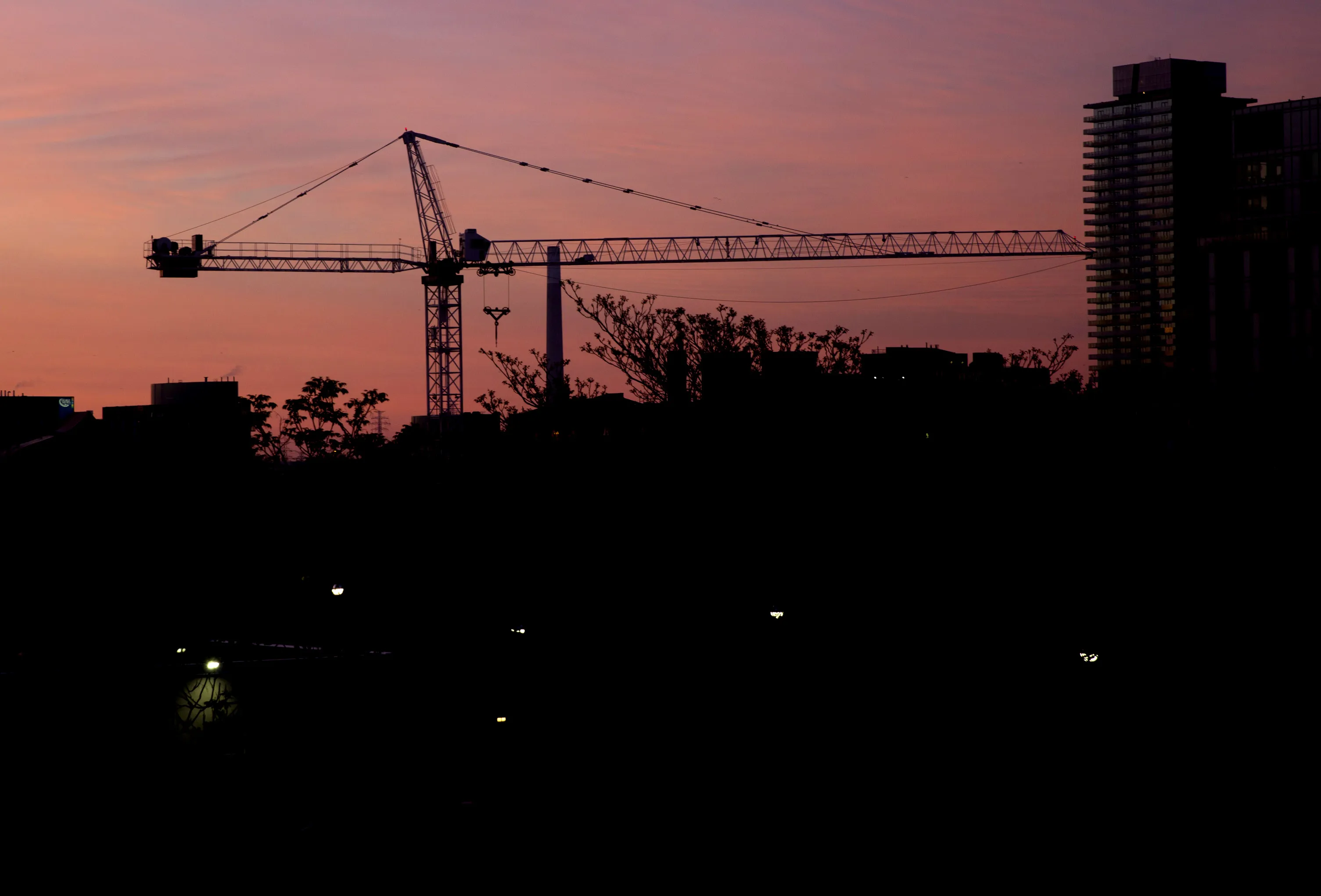 A crane at a condominium construction site stands at dawn in Toronto, Ontario, Canada, on Saturday, May 27, 2017. Canadian mortgage growth is slowing as the country's policy makers step up efforts to cool overheated housing markets in Vancouver and Toronto. With four of Canada's biggest banks reporting second-quarter results, the trend shows that growth in home loan portfolios is easing and in some cases shrinking.
