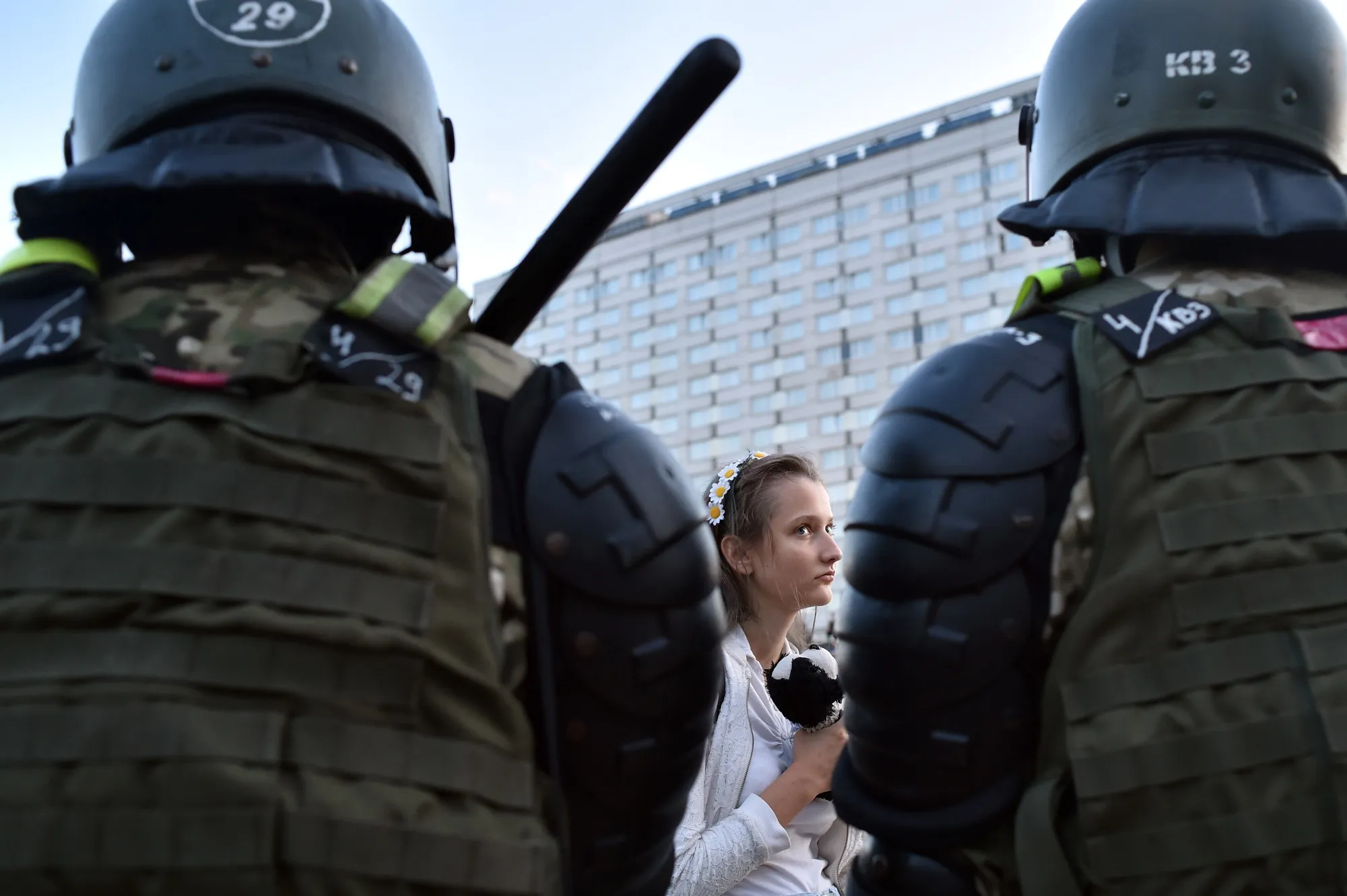 A woman stands in front of servicemen during a rally of opposition supporters in Minsk on Aug. 11.