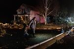 A resident with a child walks amid debris surveying damage following a severe storm in Hartland, Minnesota,&nbsp;on&nbsp;Dec. 15.
