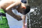 A boy cools off in a water fountain in New York's Central Park.