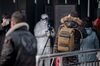 Security personnel check the temperature of people with an advanced thermo camera at a subway station in Beijing on Jan. 27, 2020.