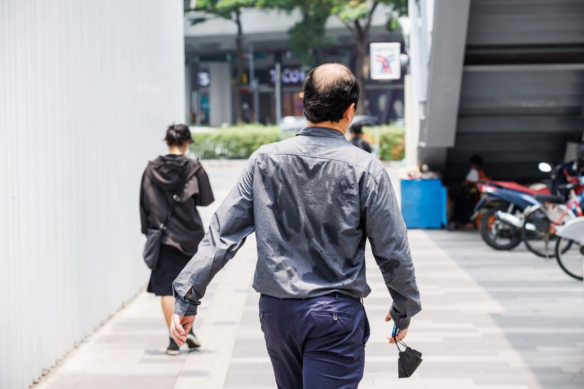 A pedestrians with a sweat-soaked shirt during a heat wave in Bangkok, Thailand, on Thursday, April 27, 2023.&nbsp;
