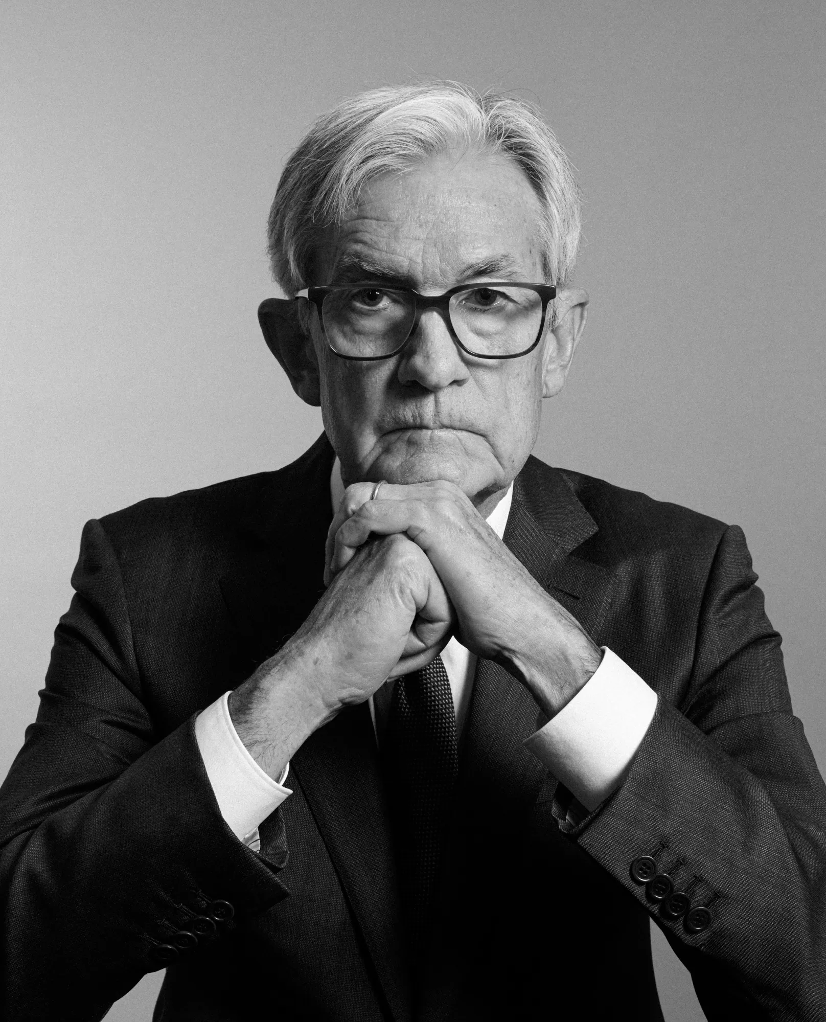 Black and white portrait of Jerome Powell with his head resting on his fists at the Fed on May 8th, 2026.