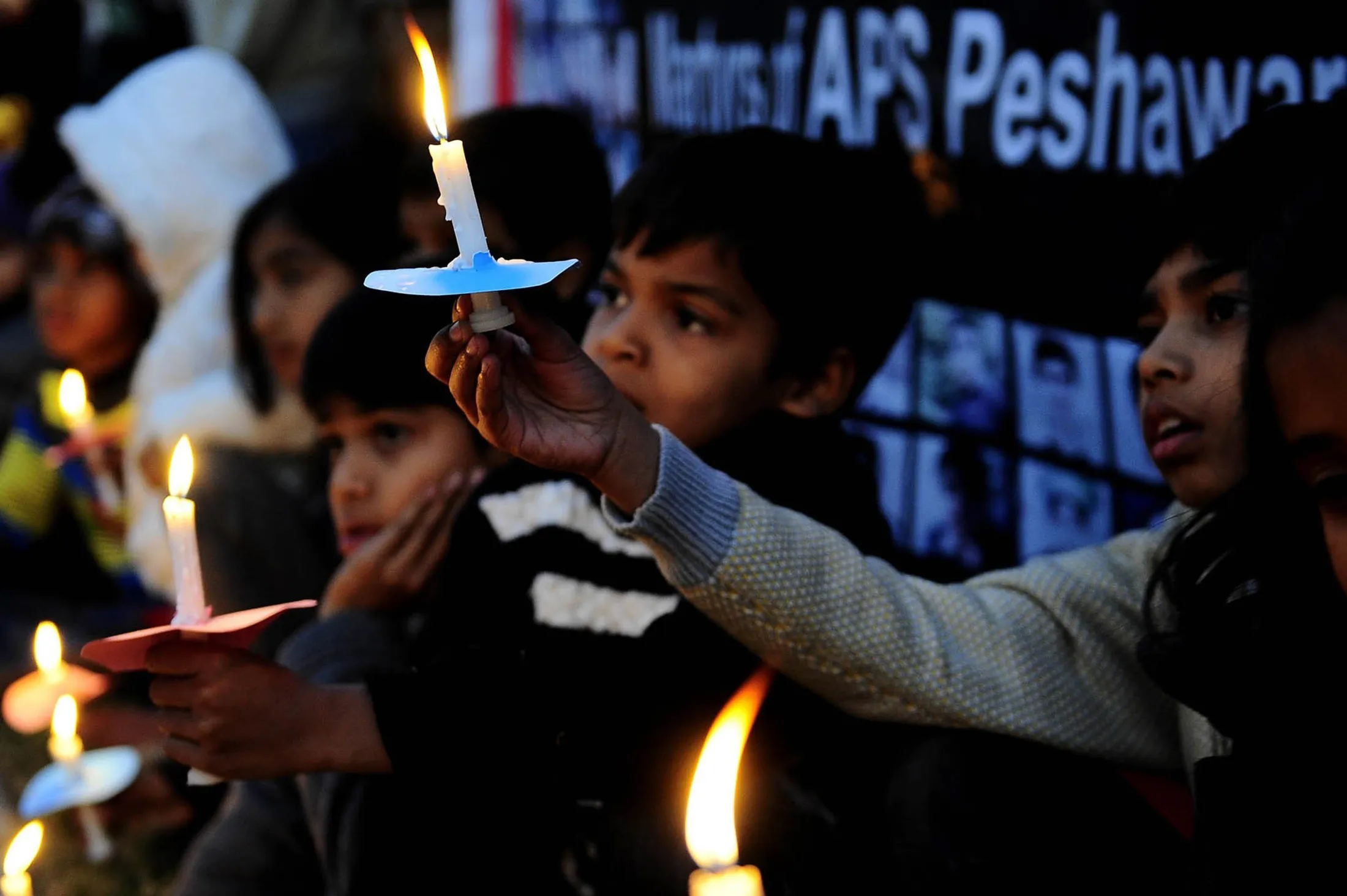 Pakistani children hold lighted candles during a tribute ceremony for the victims of the Peshawar school attack, in Islamabad, on Dec. 15.
