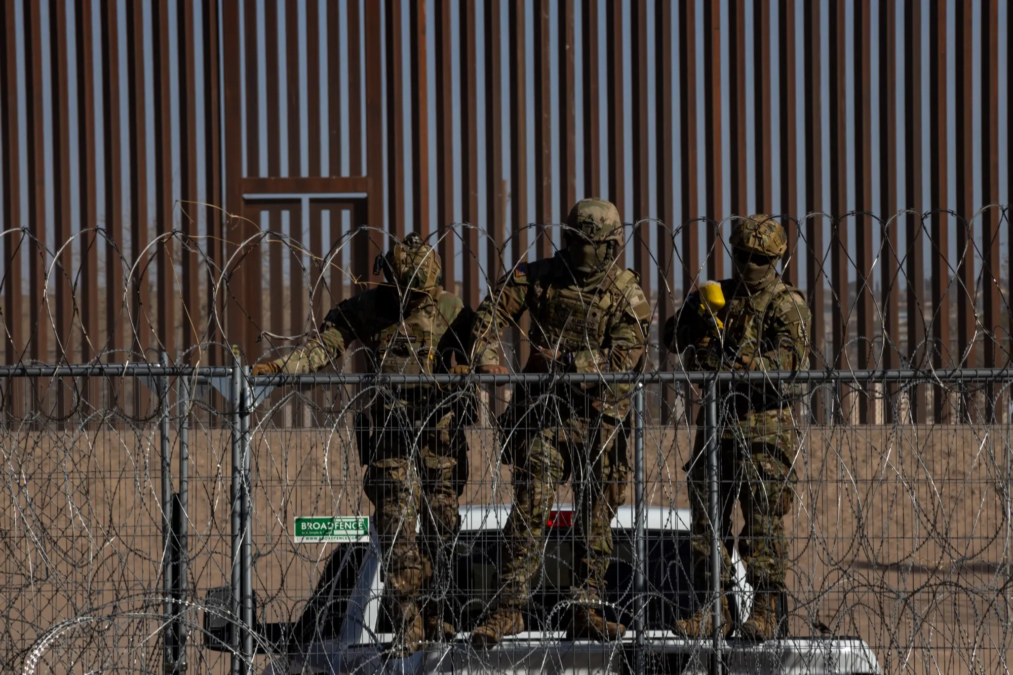 Members of the Texas Army National Guard monitor migrants along the US-Mexico border in Juarez.
