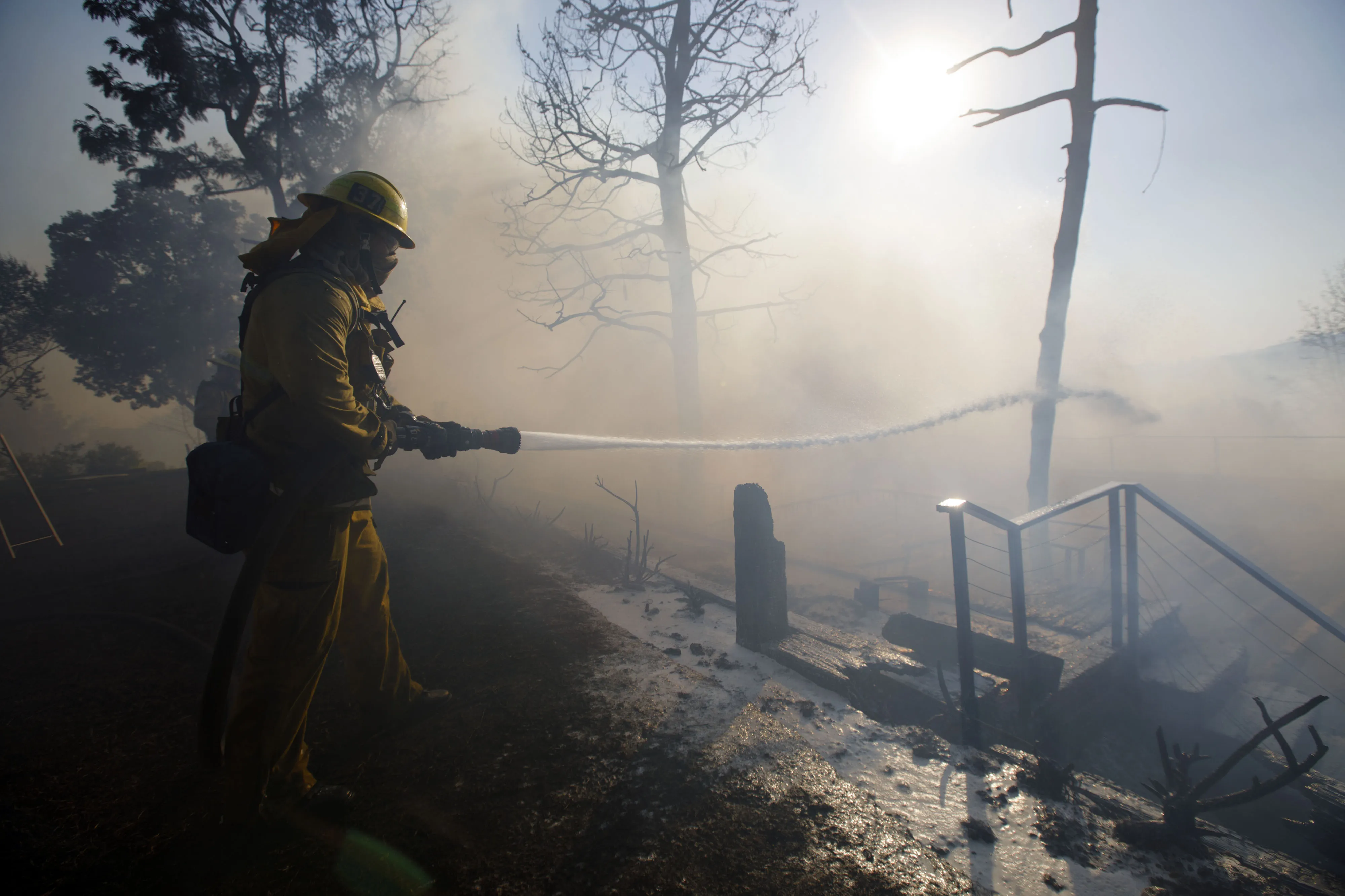 A firefighter hoses down a home's deck during the Skirball Fire in the Bel Air neighborhood of Los Angeles, California, U.S., on&nbsp;December 6, 2017.