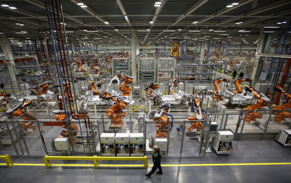An employee monitors&nbsp;robots working at&nbsp;the BMW Cowley plant in Oxford, U.K.