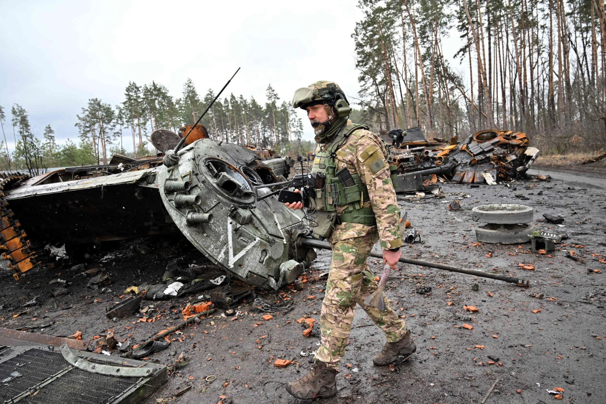 A Ukrainian serviceman walks past destroyed Russian tanks not far from the capital, Kyiv, on April 3.