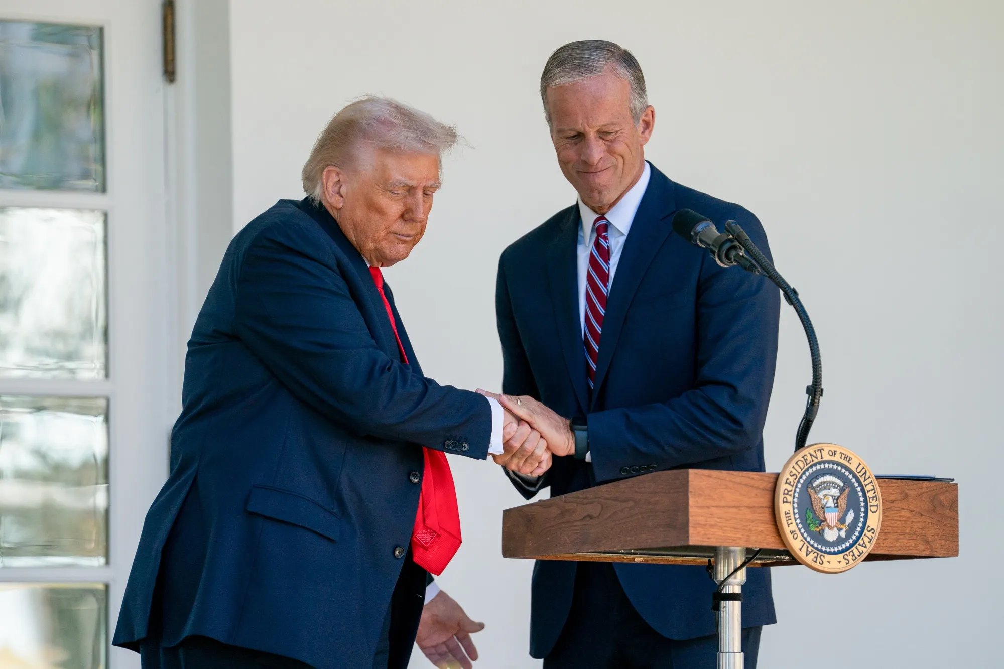 President Donald Trump, left, and Senate Majority Leader John Thune shake hands during a lunch with Republican Senators in the Rose Garden of the White House on Tuesday.