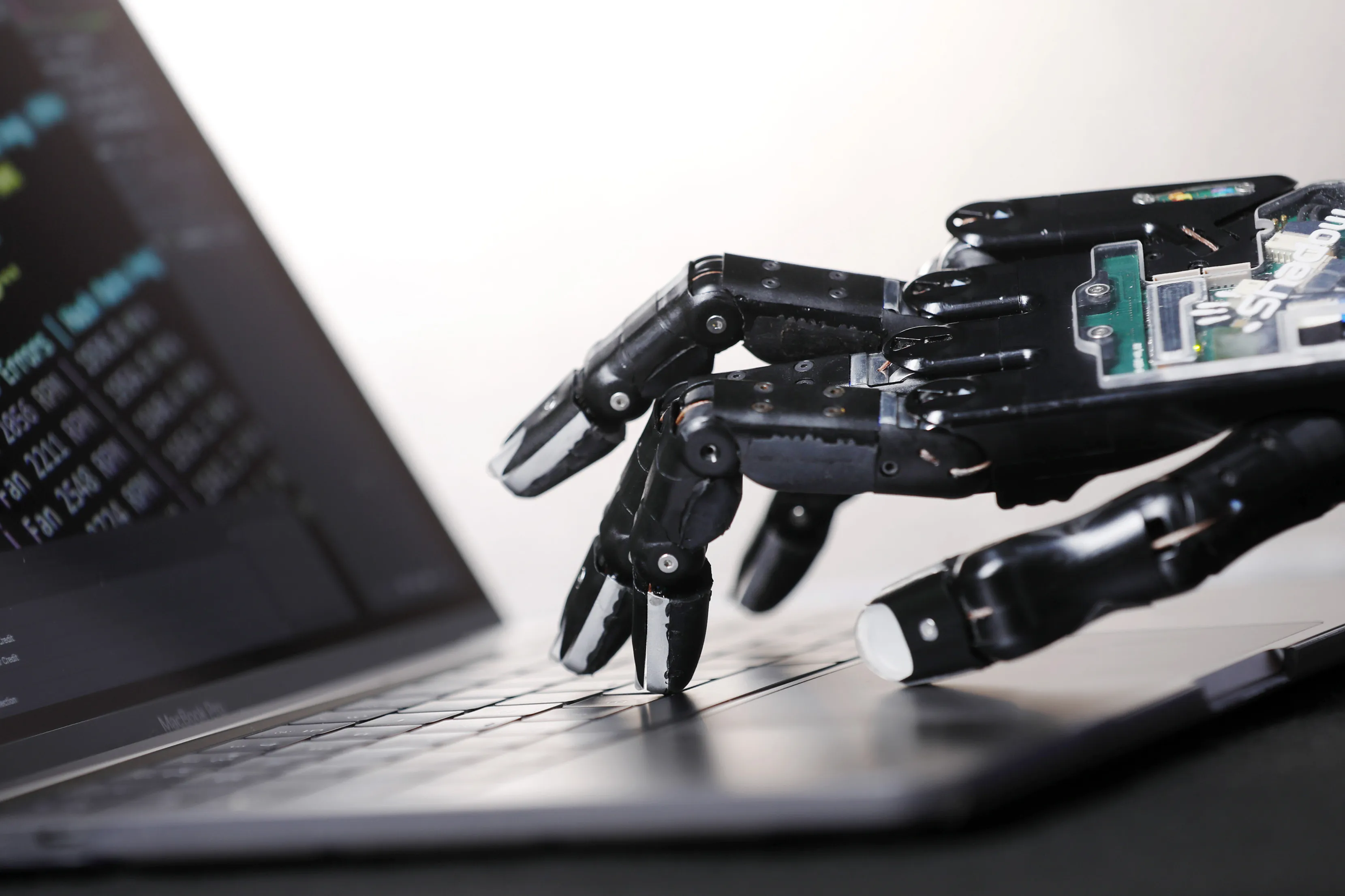 A robotic hand touches the keyboard of a laptop&nbsp;computer.