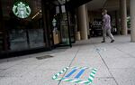 Distance markers are placed on the sidewalk outside of a Starbucks coffee shop in Washington, D.C. on May 29.