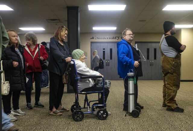 Residents stand in line to receive compensation checks. 