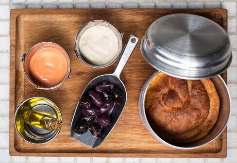 Yemeni pot-baked bread is served with tahini and velvet tomatoes.