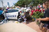 A woman places flowers at a memorial outside the Dallas Police Headquarters on July 8, 2016, following the sniper shooting during a peaceful protest the night before.The gunman who opened fire on Dallas officers during a protest against US police brutality, leaving five dead and seven others wounded, told negotiators he wanted to kill white cops, the city's police chief said July 8. / AFP / Laura Buckman        (Photo credit should read LAURA BUCKMAN/AFP/Getty Images)