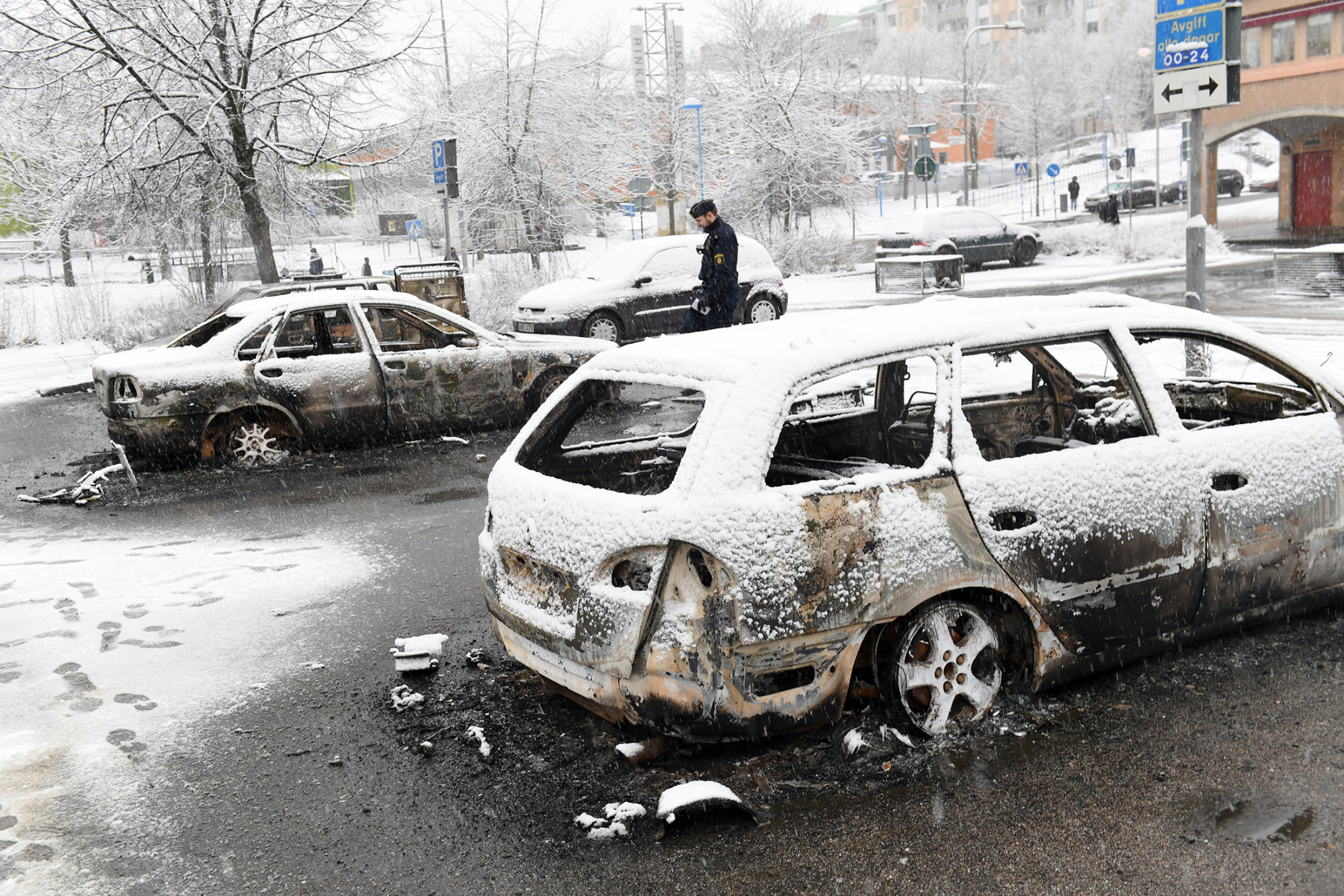 A policeman investigates a burned out car in the suburb of Rinkeby, outside Stockholm, on Feb. 20.
