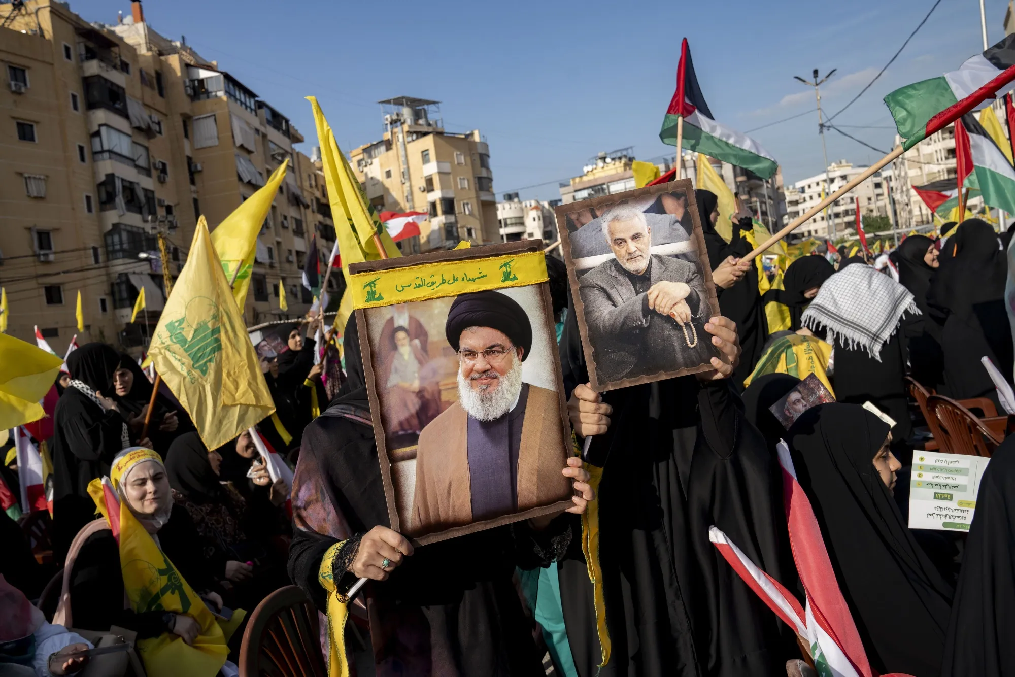 Supporters hold placards at a broadcast of a speech by Hassan Nasrallah, leader of Hezbollah, in Beirut in November.