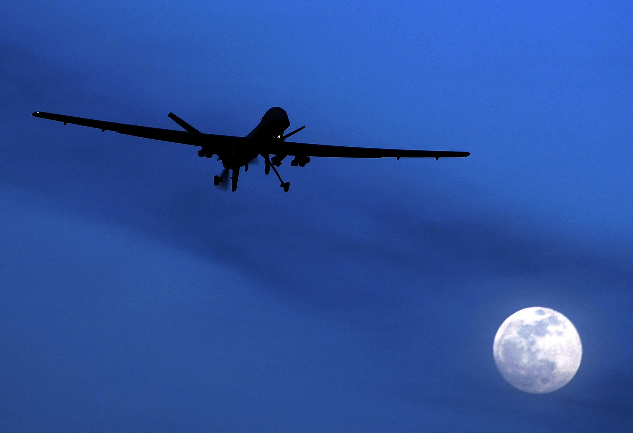 An unmanned U.S. Predator drone flies over Kandahar Air Field, southern Afghanistan on a moonlit night.
