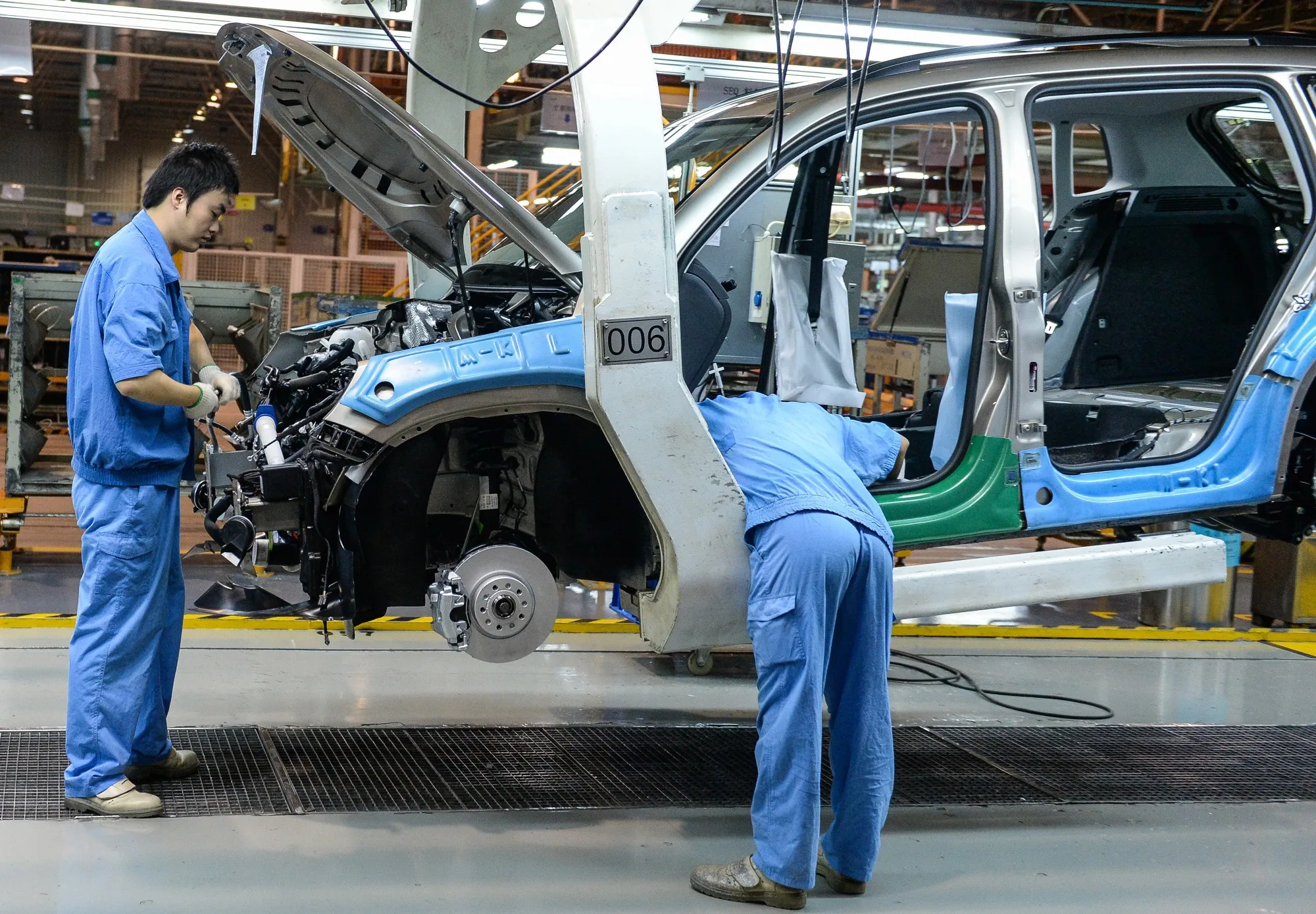 Employees check a VW Tiguan being built in Shanghai, in 2015.