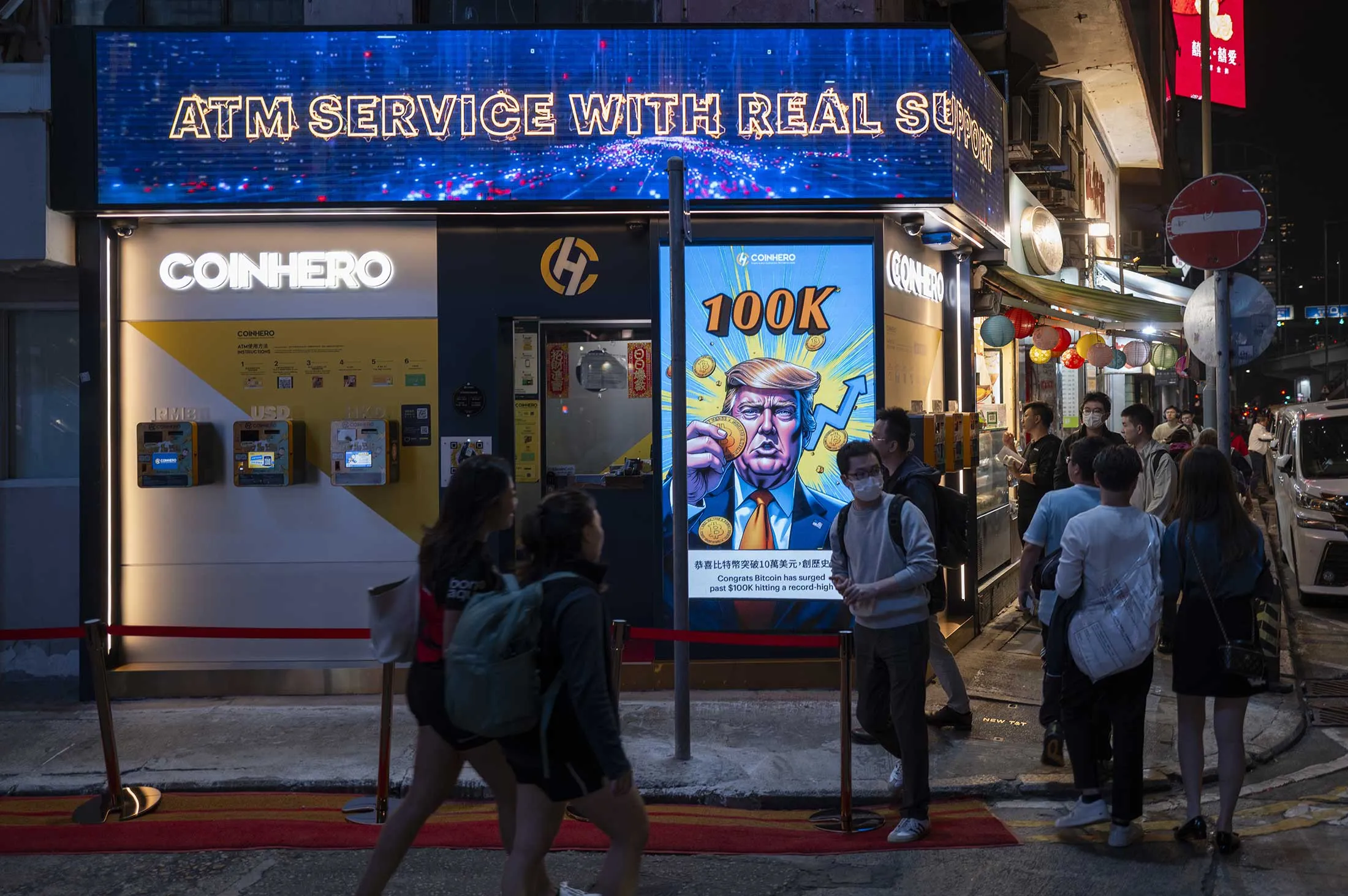 Un dessin animé à l'extérieur d'un magasin Coinhero à Hong Kong marque l'occasion pour laquelle Bitcoin a atteint plus de 100 000 $.