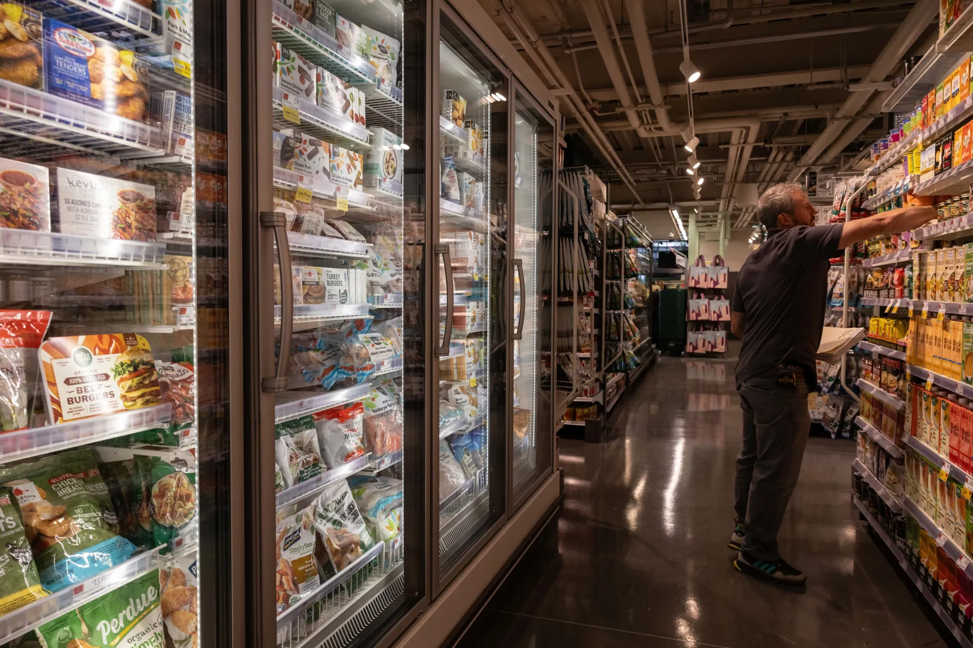 A worker stocks shelves in a Whole Foods Market location in New York.