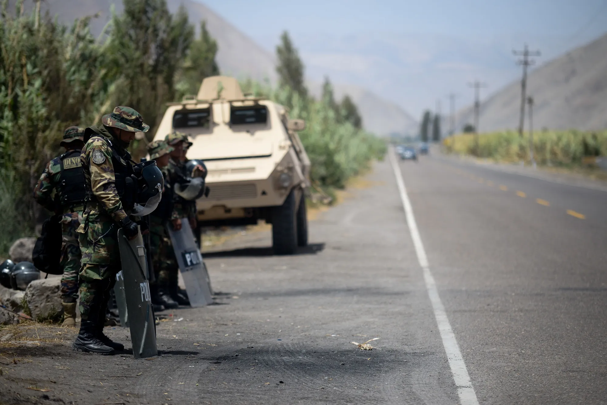 Police officers stand guard on a road in the Tambo Valley of Arequipa, Peru.&nbsp;