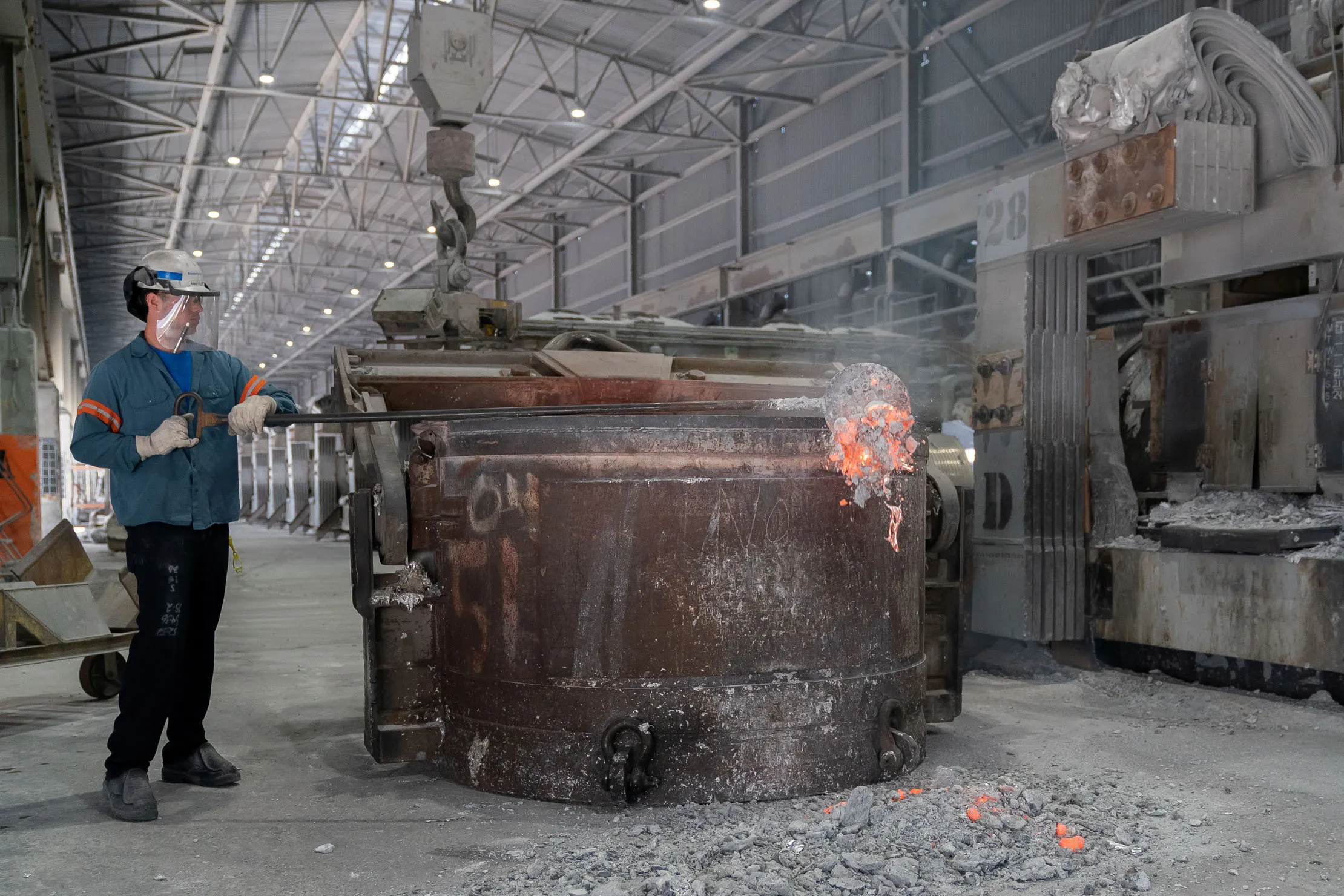 A worker clears slag off the top of molten aluminum at a Century Aluminum Co. facility in Hawesville, Ky.