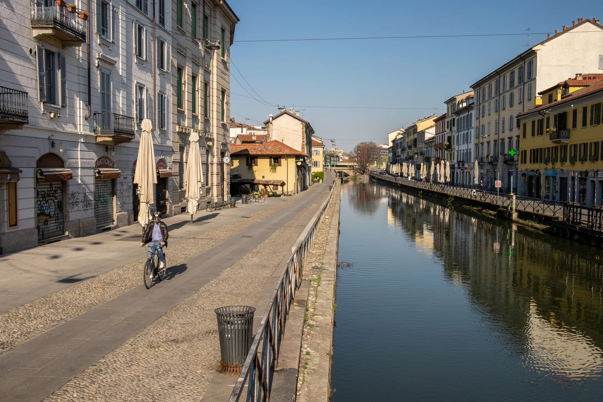 A cyclist, wearing a protective face mask, passes along the banks of the Navigli canal system in Milan, Italy, on April 8.